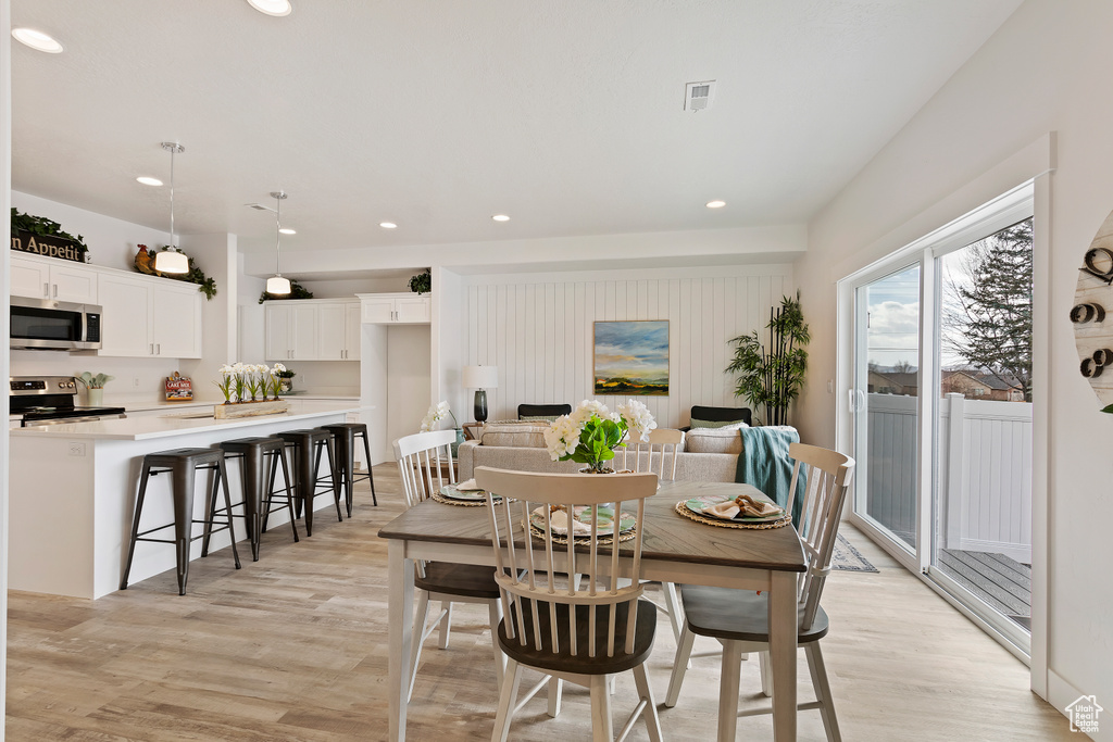 Dining space with light wood finished floors and recessed lighting