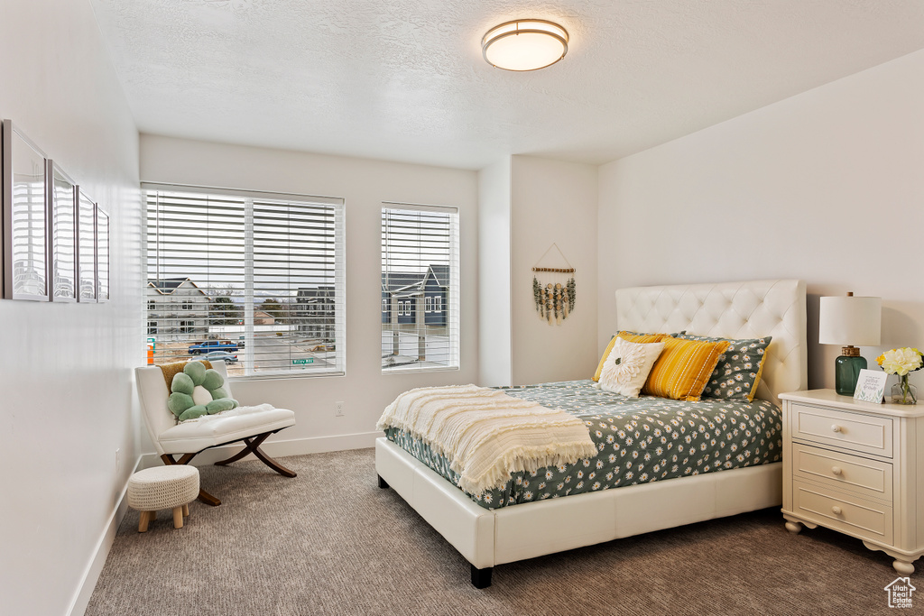 Bedroom with dark carpet and baseboards