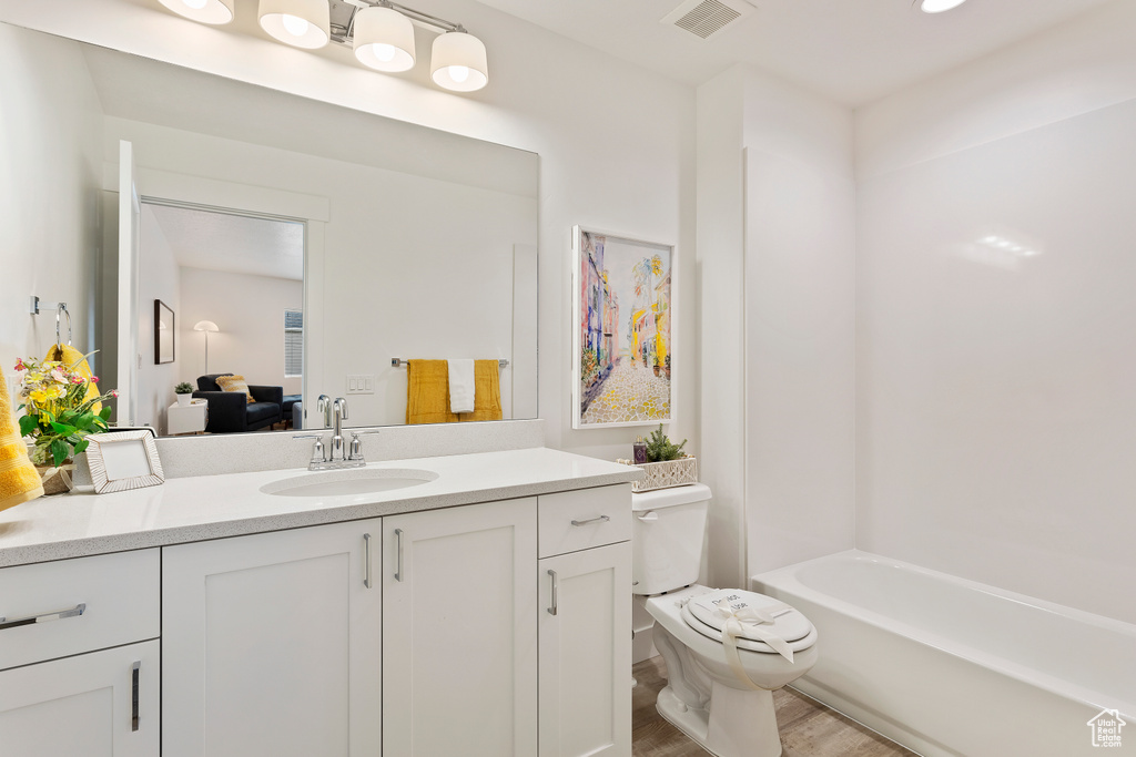 Full bath with vanity and wood finished floors