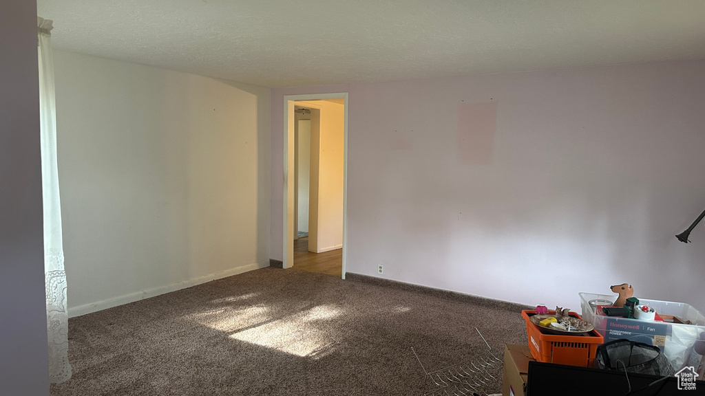 Spare room featuring carpet and baseboards