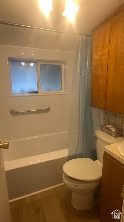 Full bath with vanity, wood finished floors, and shower / bathtub combination with curtain