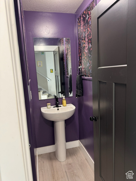 Bathroom featuring a textured ceiling and wood finished floors