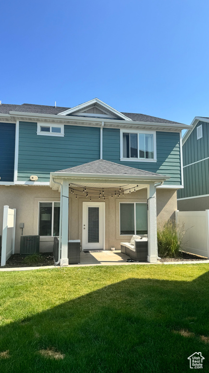 Rear view of property with a yard, a patio area, and stucco siding