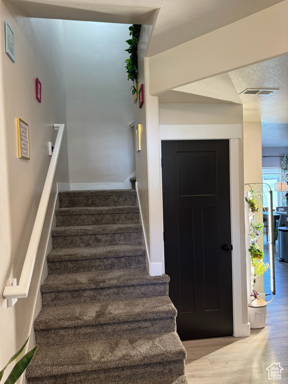Stairway featuring wood finished floors and baseboards