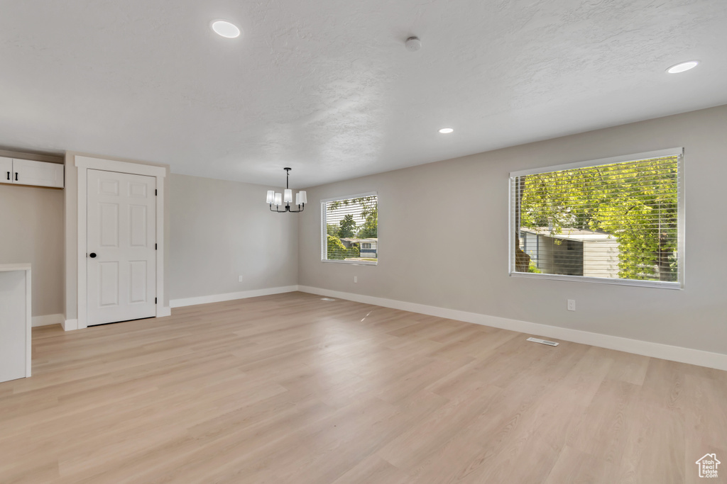 Unfurnished room featuring a chandelier, light wood finished floors, recessed lighting, and a smoke detector