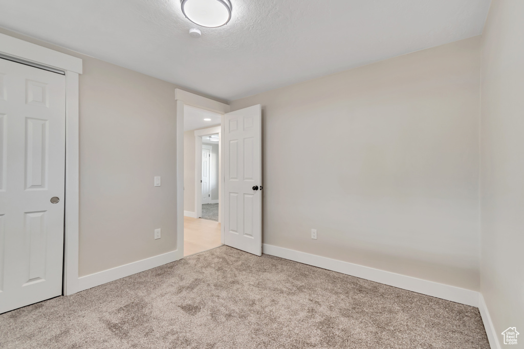 Unfurnished bedroom with carpet flooring and baseboards