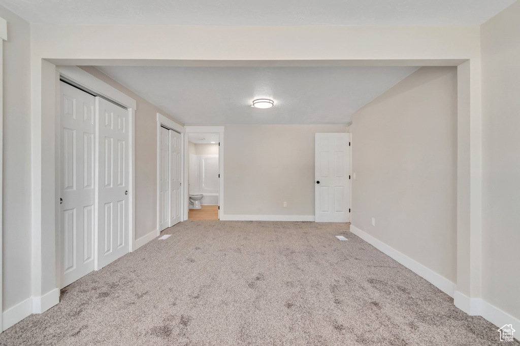 Unfurnished bedroom with carpet and multiple closets