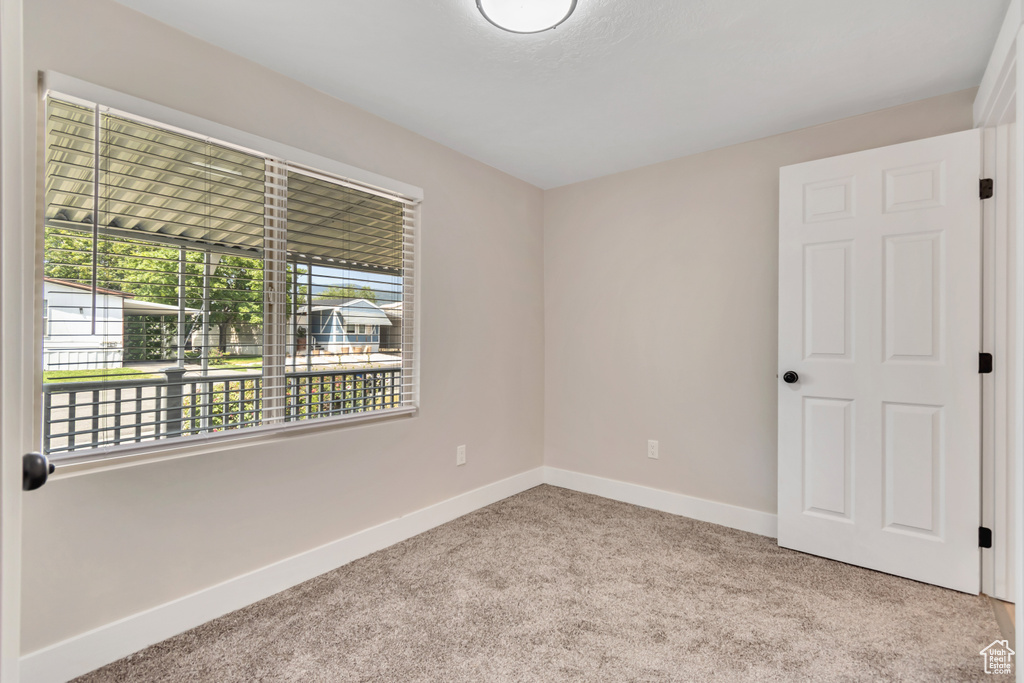 Spare room featuring carpet flooring and baseboards