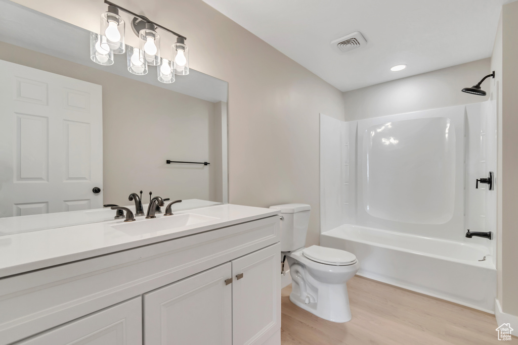 Full bathroom with wood finished floors, vanity, and shower / washtub combination