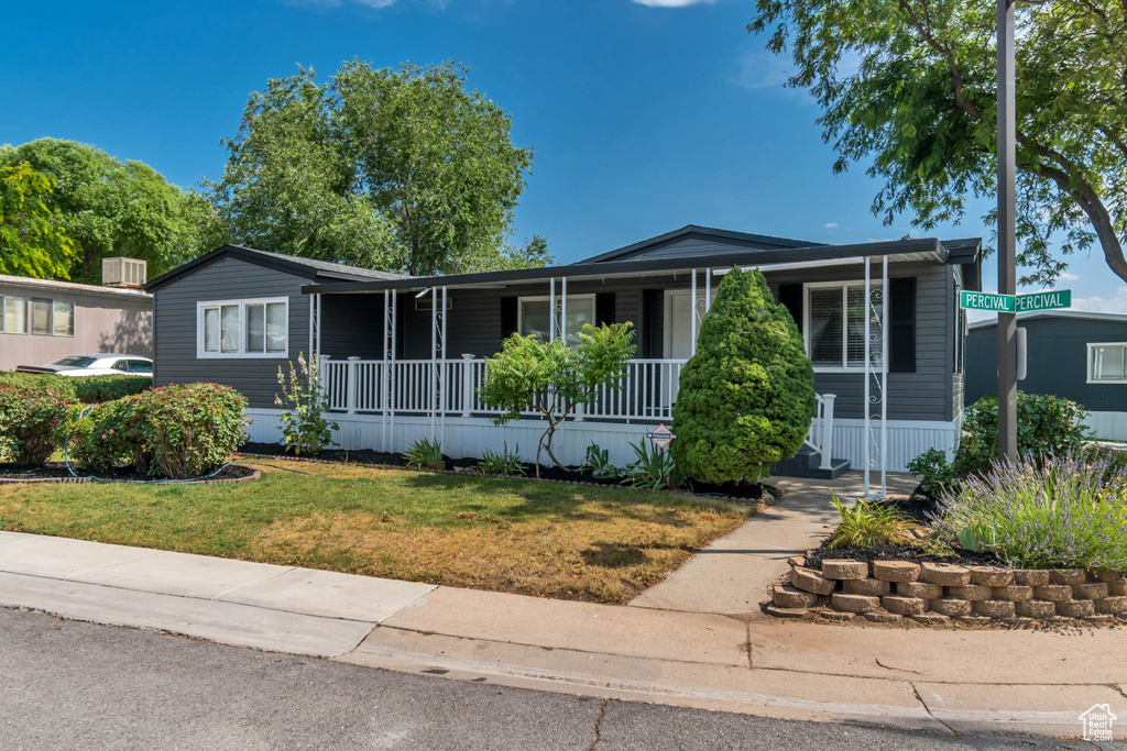 Manufactured / mobile home with covered porch and a front lawn