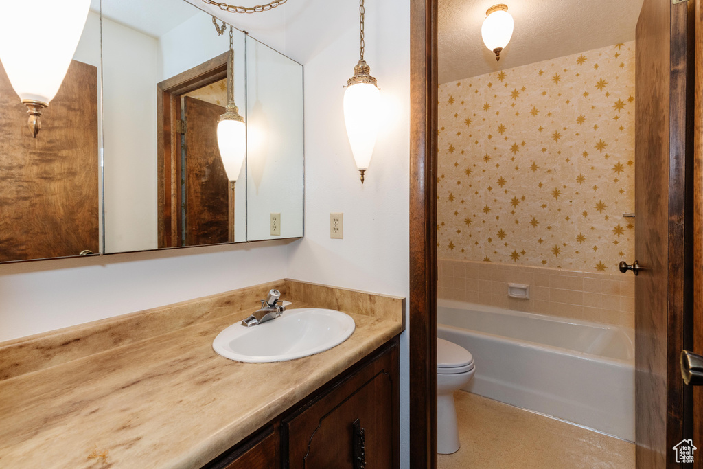 Full bath with vanity, shower / bathtub combination, and wallpapered walls