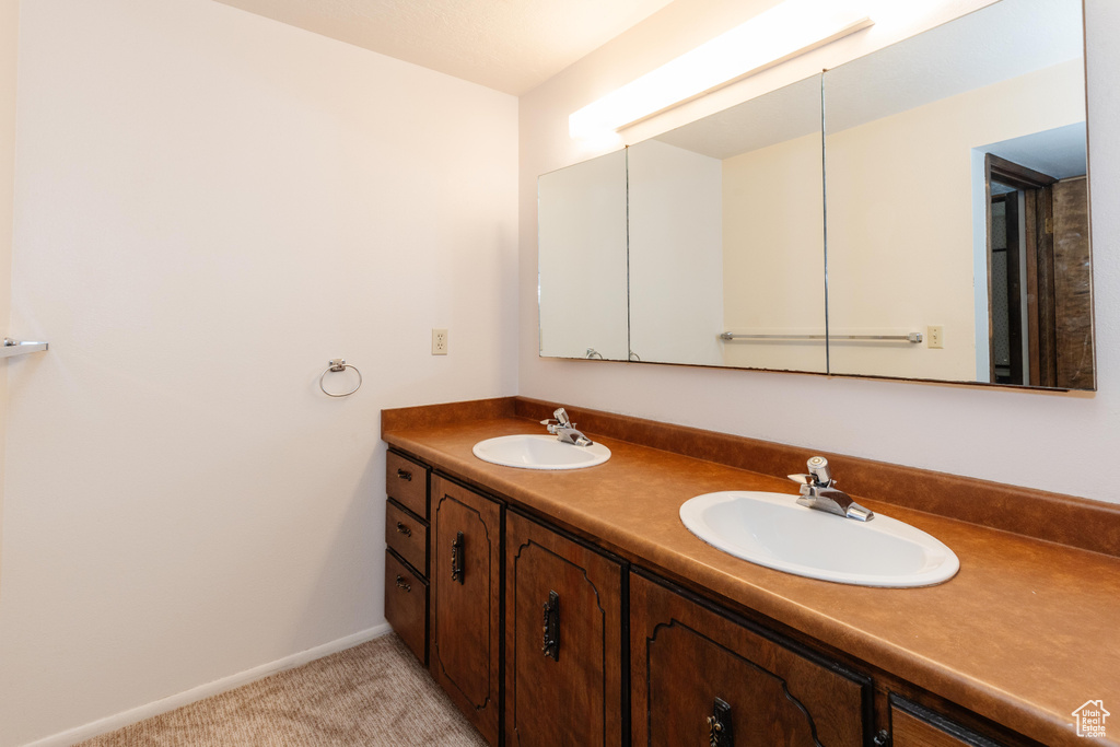 Full bath with double vanity and baseboards