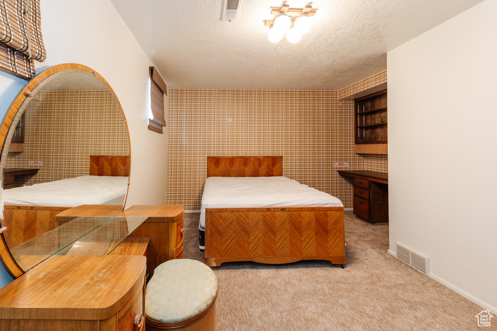 Carpeted bedroom featuring a textured ceiling