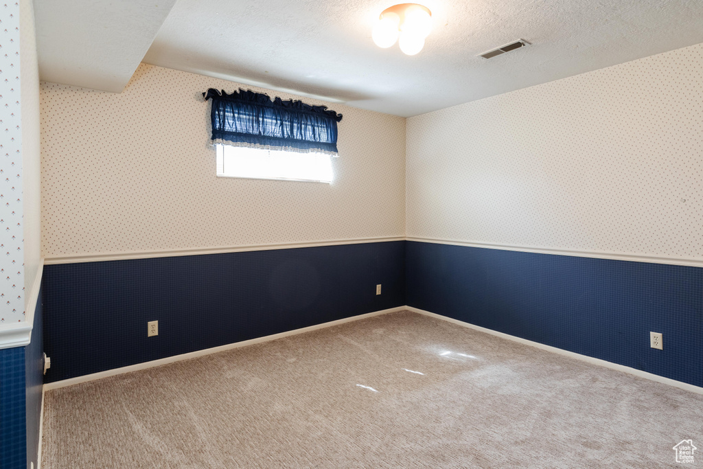Unfurnished room featuring carpet floors and wallpapered walls