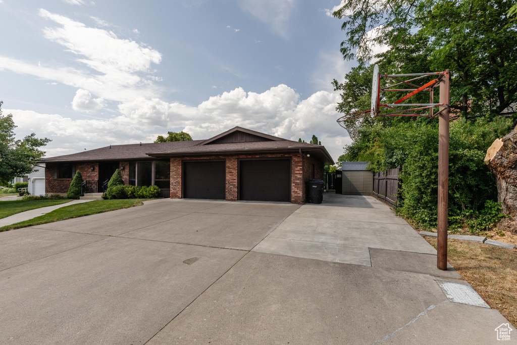 View of front of home featuring brick siding, an attached garage, and driveway