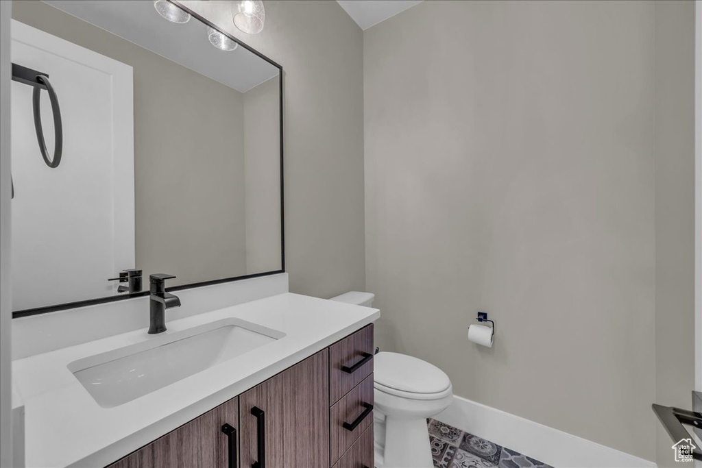 Half bathroom with vanity and tile patterned floors