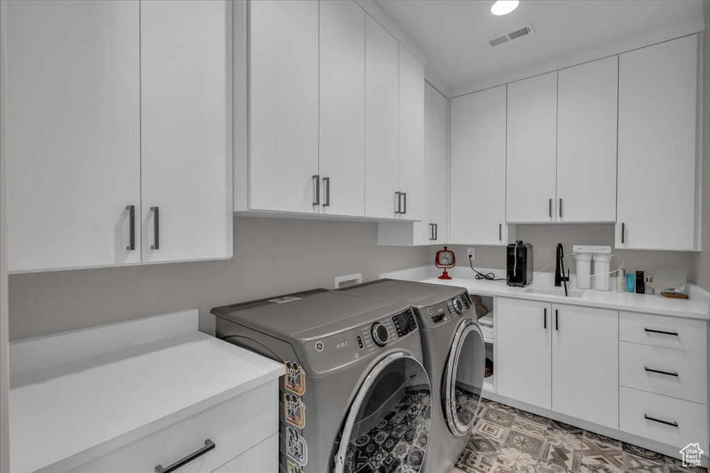 Laundry area with independent washer and dryer and cabinet space