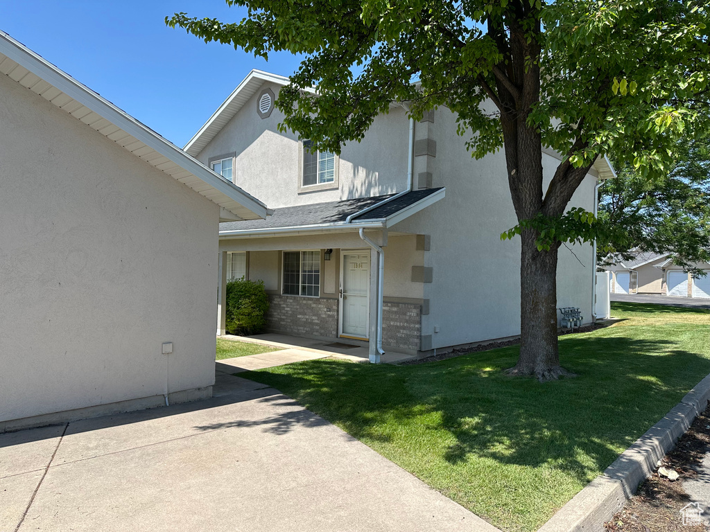 View of front of house featuring a front yard, stucco siding, and brick siding