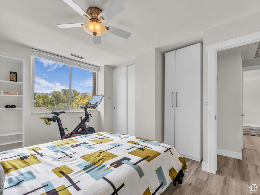 Bedroom with light wood-style floors and a ceiling fan