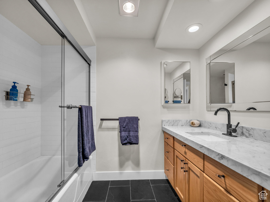 Full bathroom featuring vanity, tile patterned flooring, and shower / bath combination with glass door