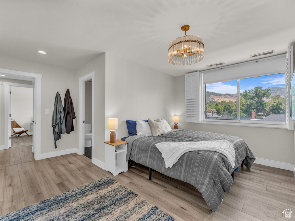 Bedroom with a chandelier, wood finished floors, and recessed lighting