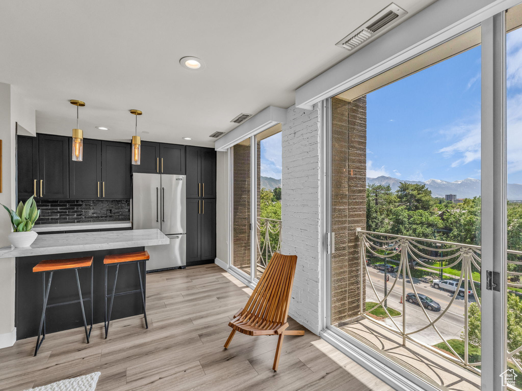 Kitchen featuring high end refrigerator, dark cabinets, backsplash, a mountain view, and recessed lighting