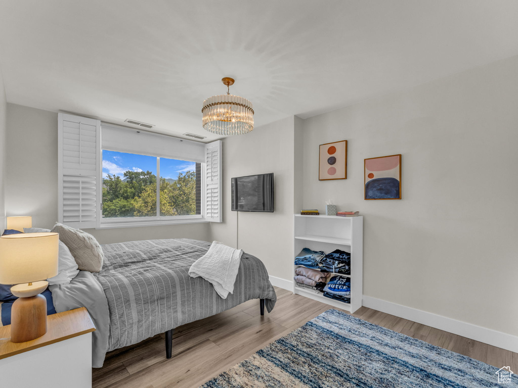 Bedroom with a chandelier and wood finished floors