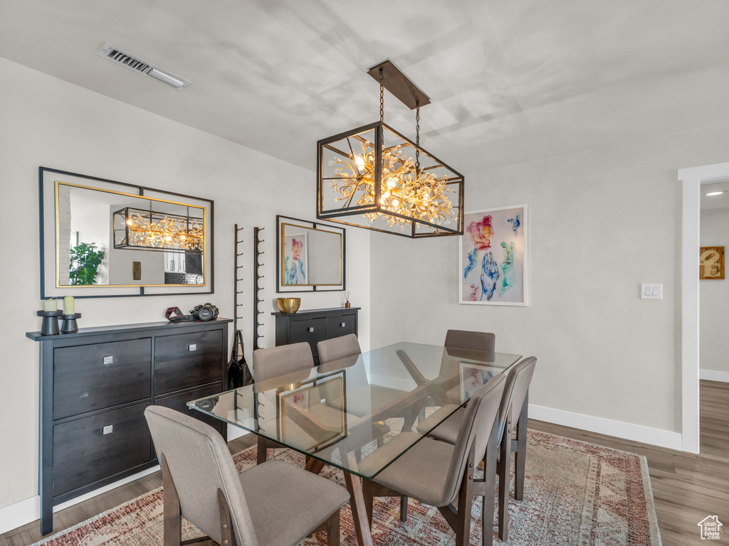 Dining area with a chandelier and wood finished floors