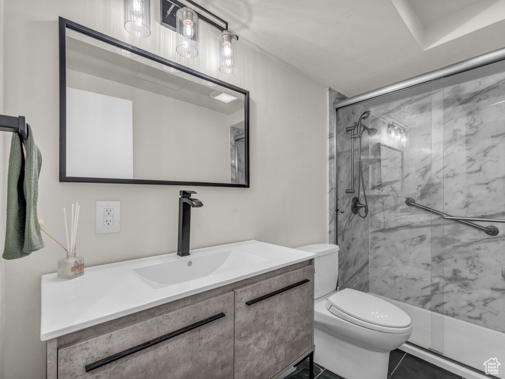 Bathroom with vanity, a marble finish shower, and tile patterned flooring