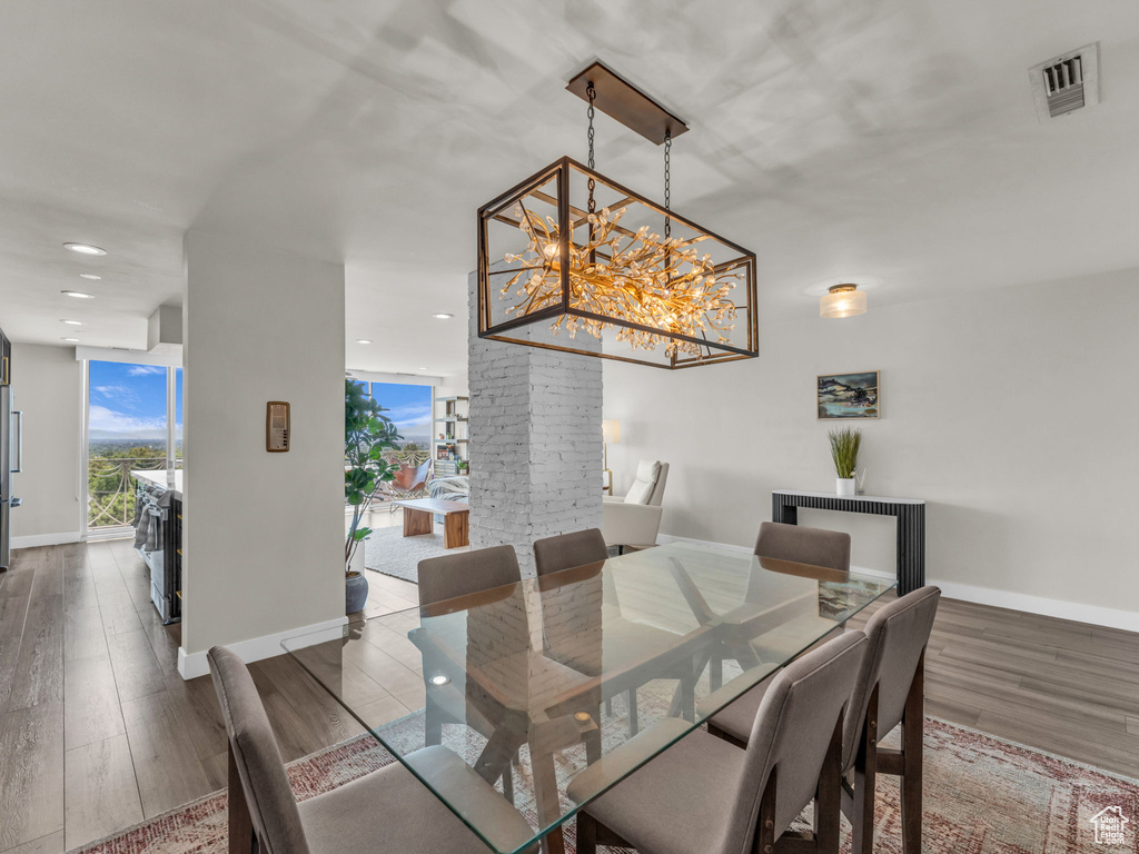 Dining space featuring wood finished floors, recessed lighting, and a chandelier
