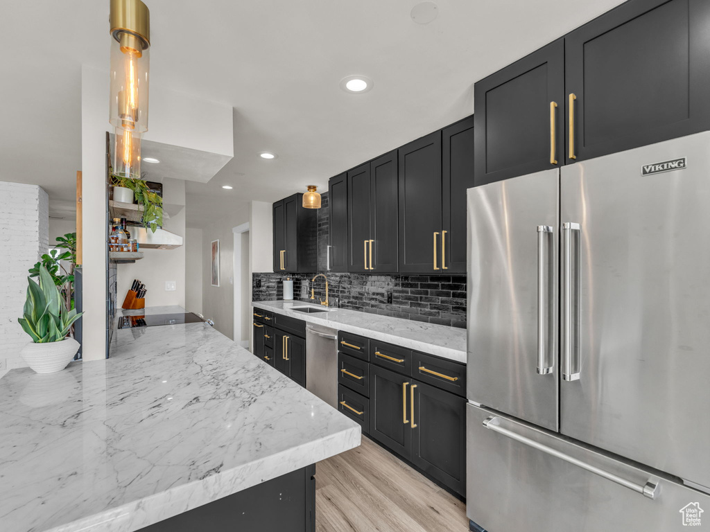 Kitchen featuring appliances with stainless steel finishes, open shelves, recessed lighting, decorative backsplash, and dark cabinetry