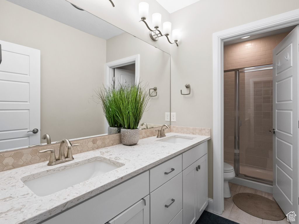 Bathroom with double vanity, a stall shower, and tile patterned flooring