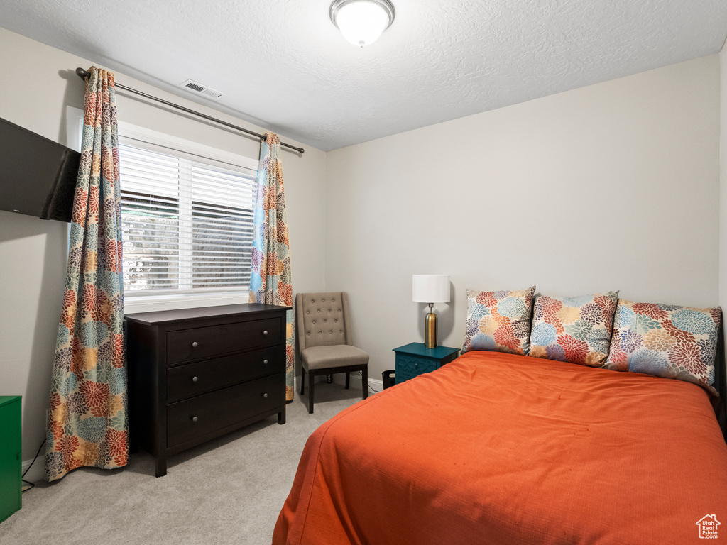 Bedroom featuring light carpet