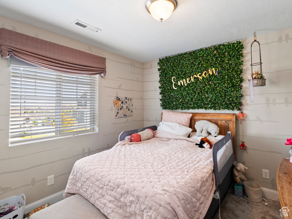 Bedroom featuring carpet and baseboards