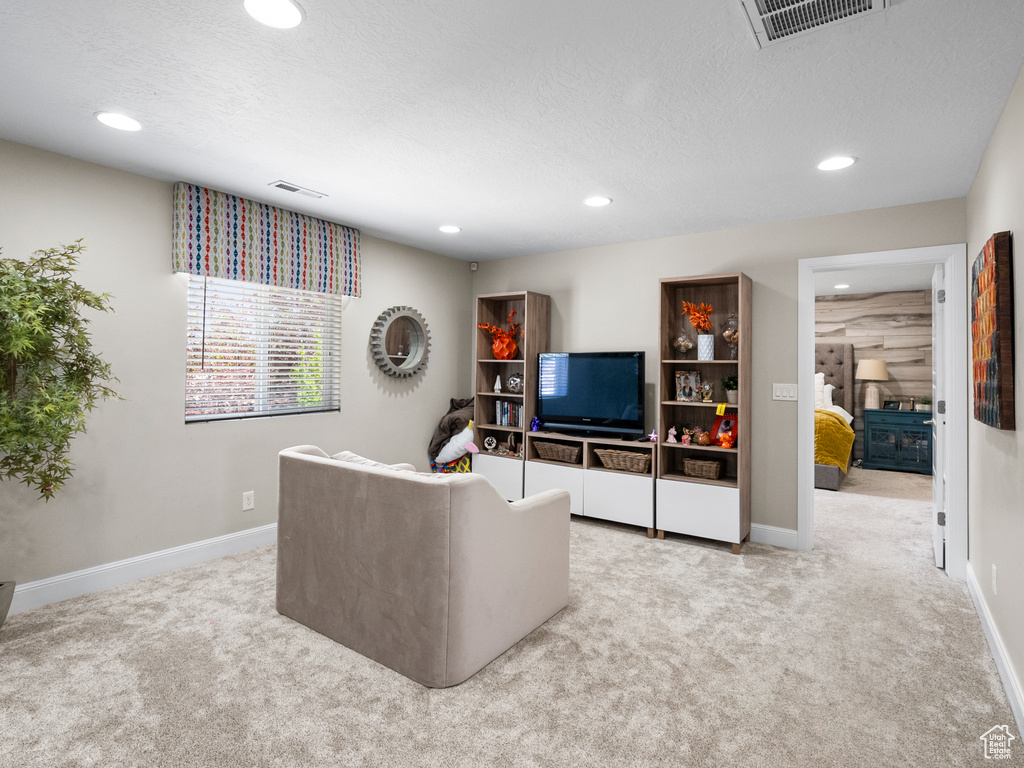 Carpeted living room with recessed lighting and a textured ceiling