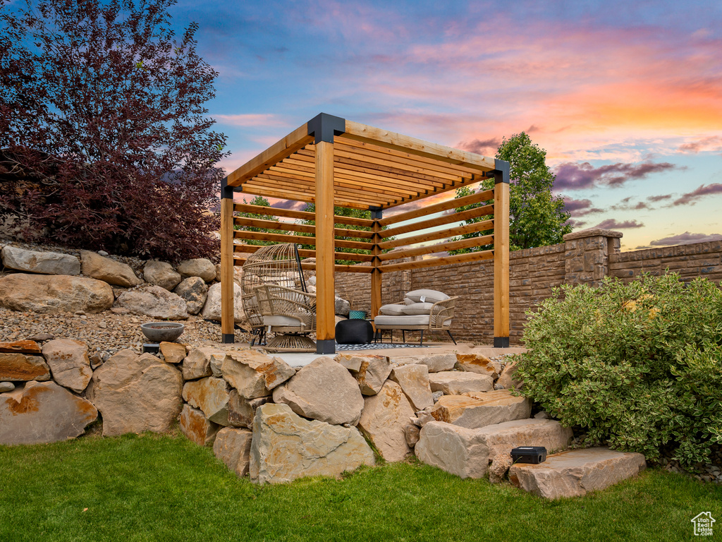 Patio terrace at dusk featuring a pergola and a patio