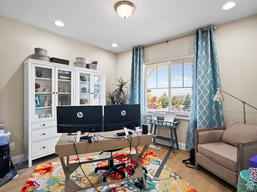 Office space featuring light wood-style floors and recessed lighting