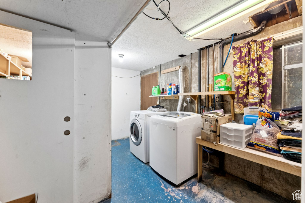 Washroom with washing machine and dryer and a textured ceiling