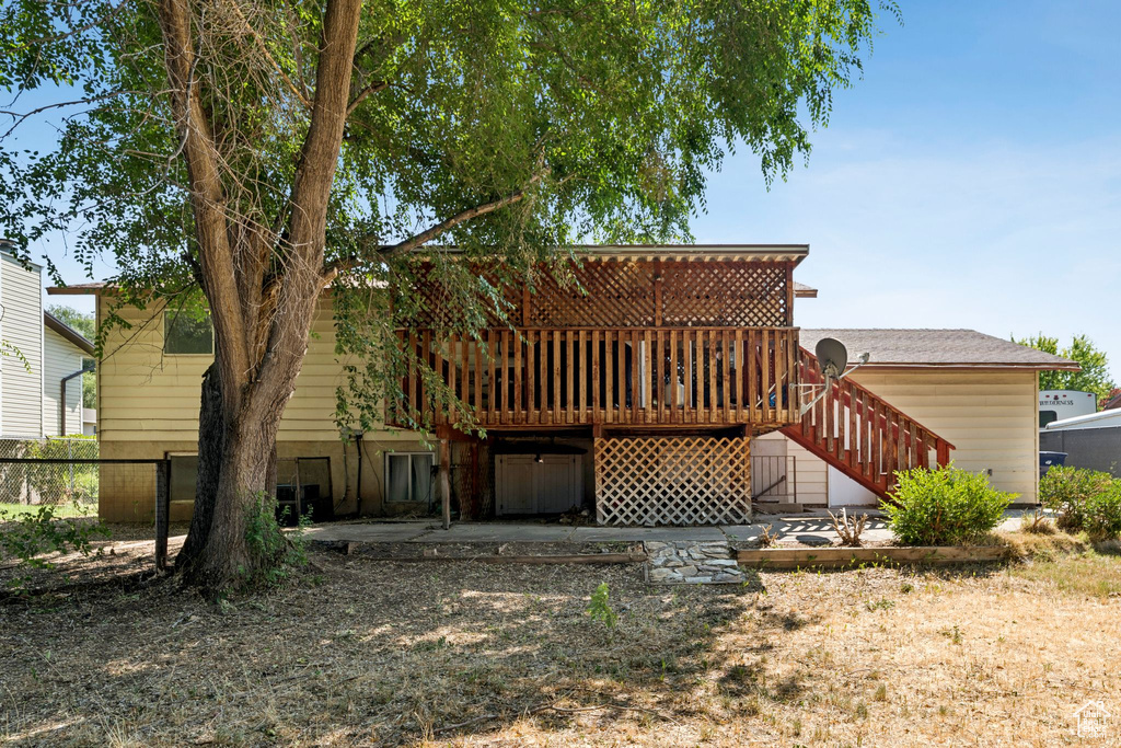 Back of property with a deck and stairs