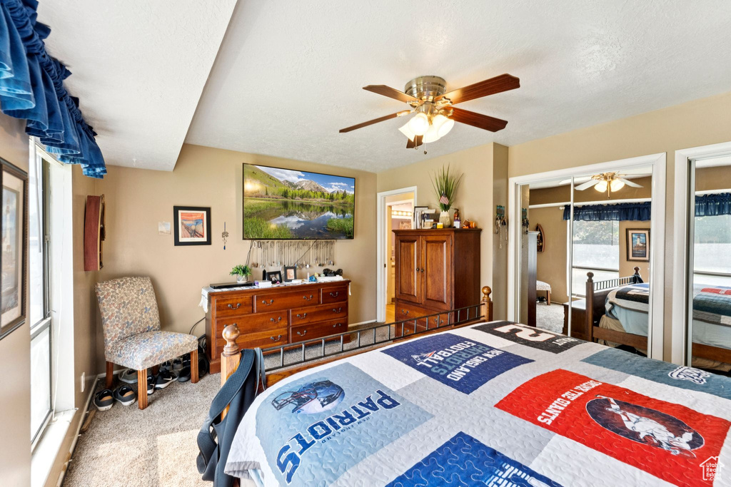 Carpeted bedroom featuring a ceiling fan