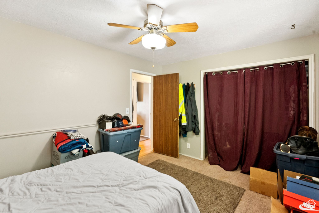 Carpeted bedroom with a ceiling fan