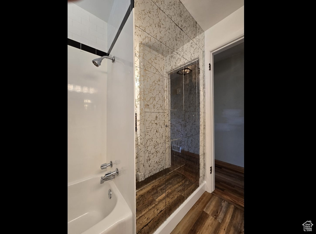 Full bath with washtub / shower combination and wood finished floors