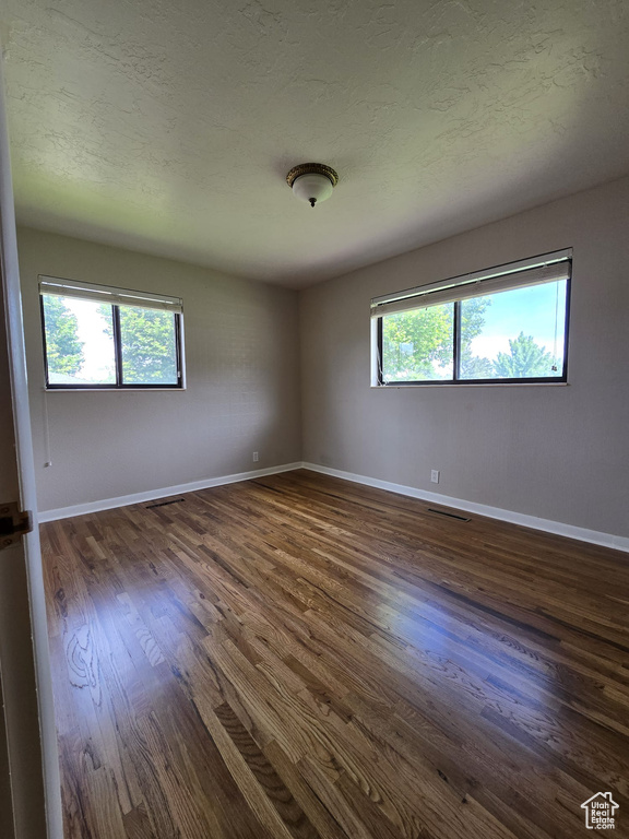 Spare room featuring dark wood finished floors