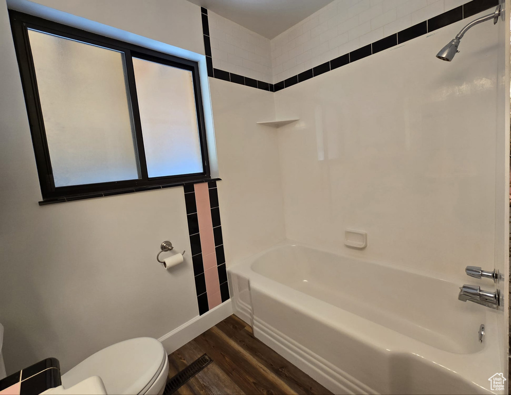 Bathroom featuring wood finished floors and shower / bath combination