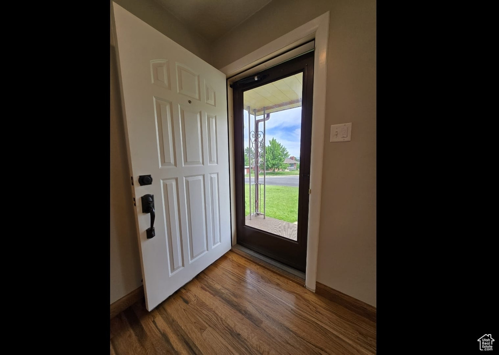 Foyer entrance with wood finished floors and baseboards