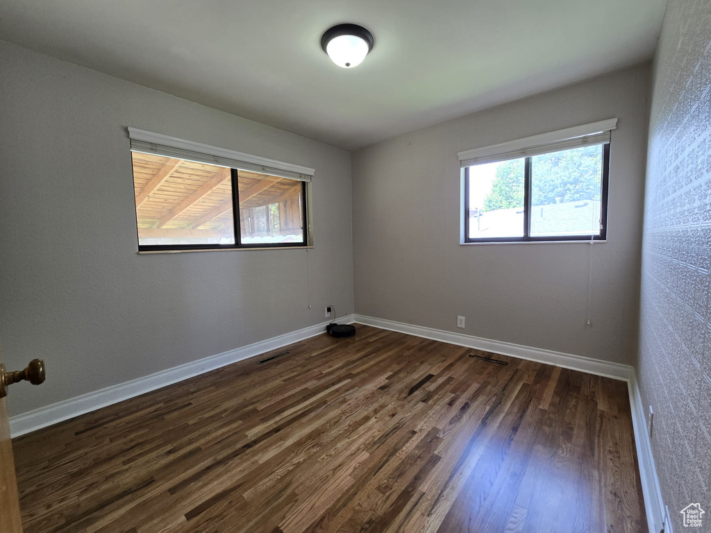 Unfurnished room with dark wood-style floors and baseboards