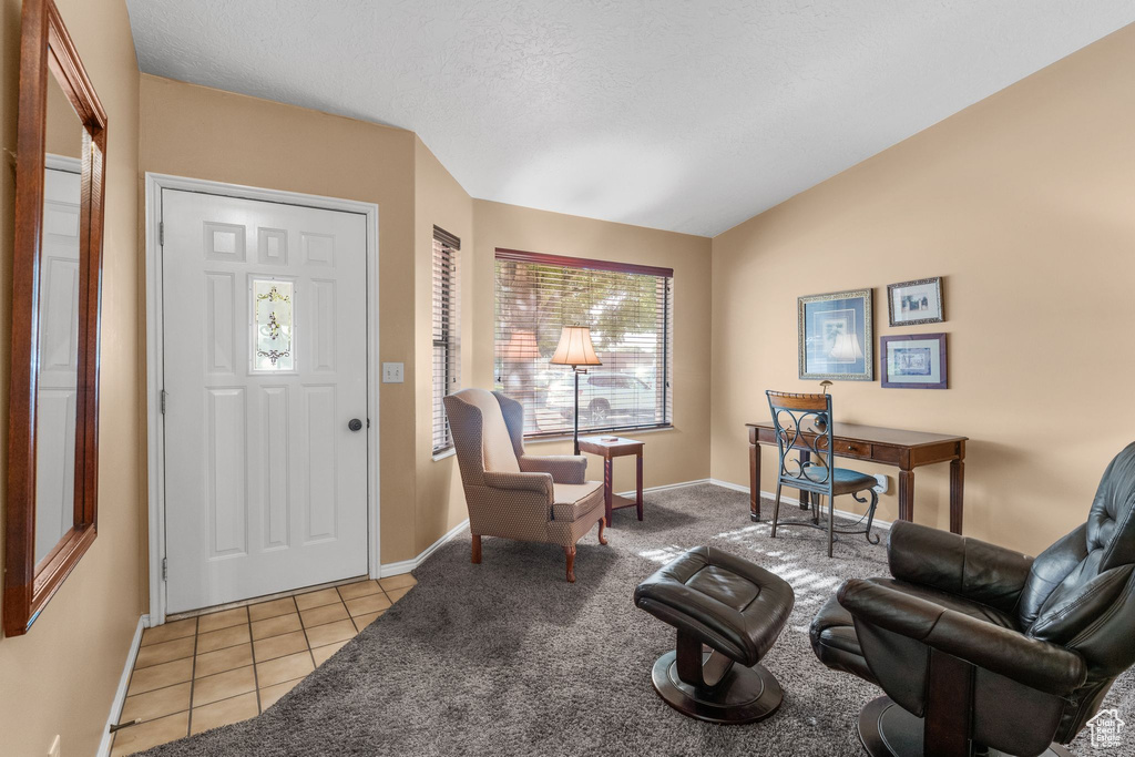 Foyer featuring light tile patterned floors and lofted ceiling