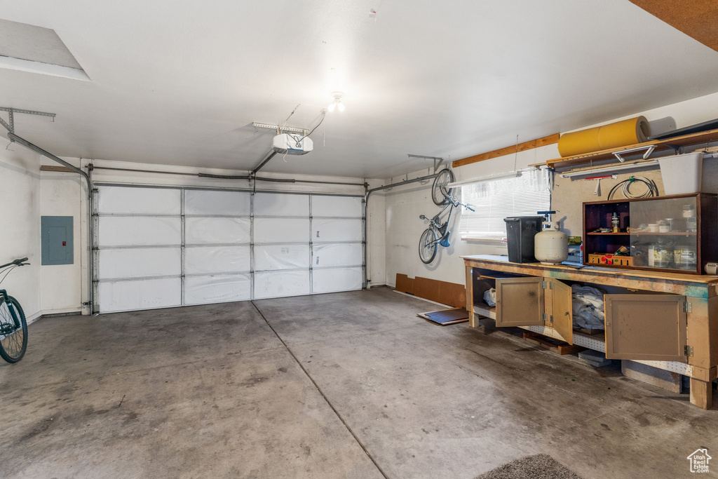 Garage featuring a garage door opener and electric panel