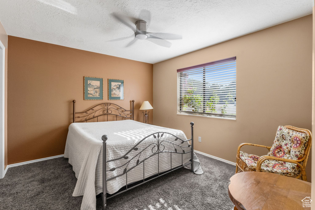 Bedroom featuring carpet floors, ceiling fan, and a textured ceiling