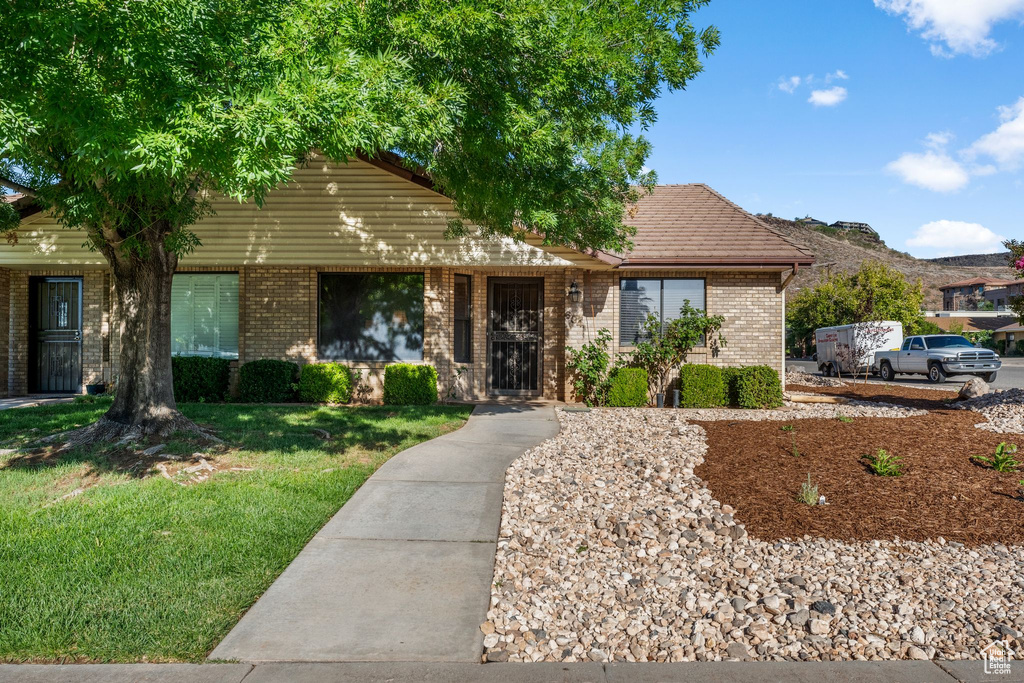 View of front of house featuring a front lawn and brick siding